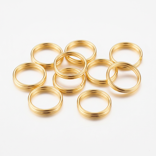 10 anillas doradas de latón sobre fondo blanco