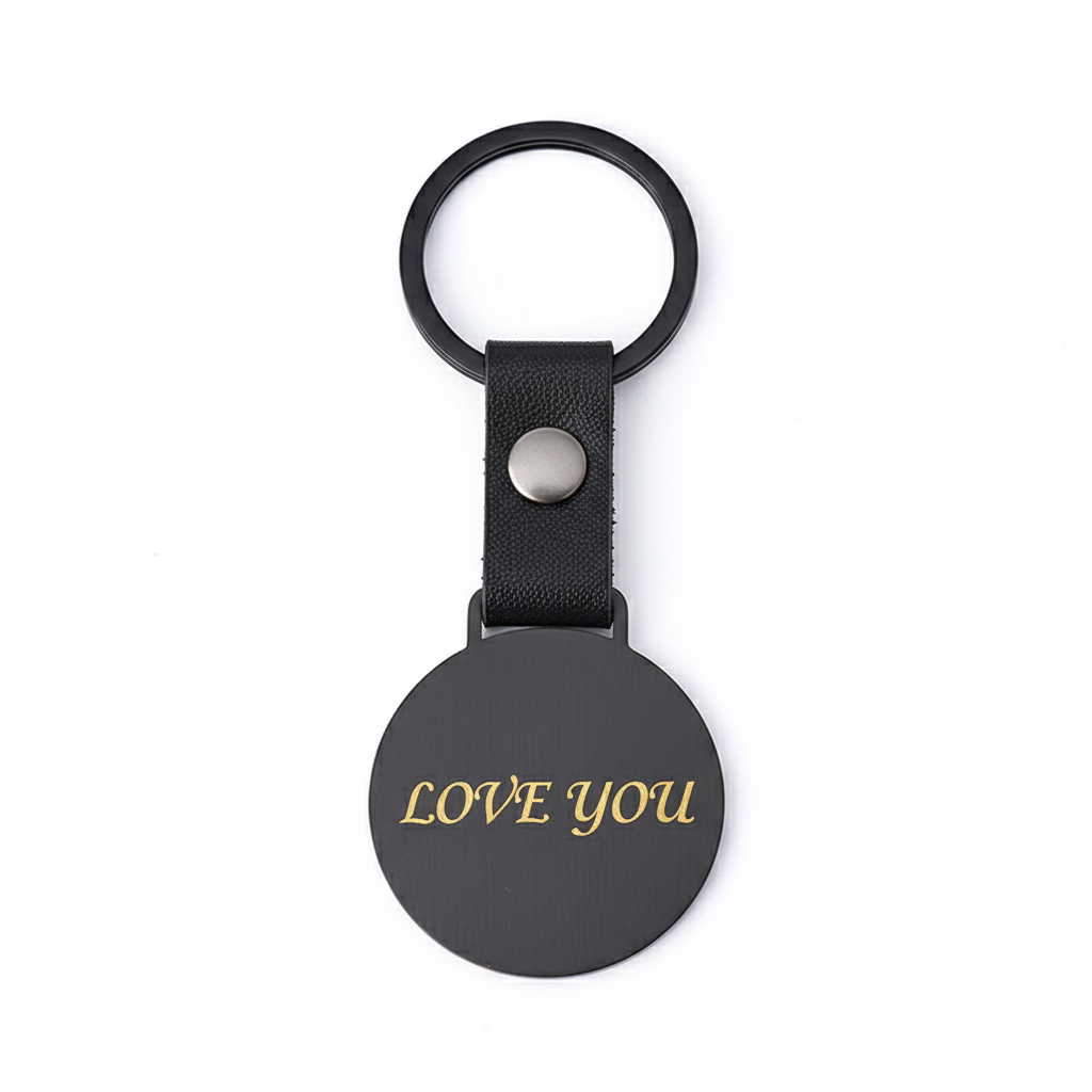 Llavero negro con grabado dorado sobre fondo blanco