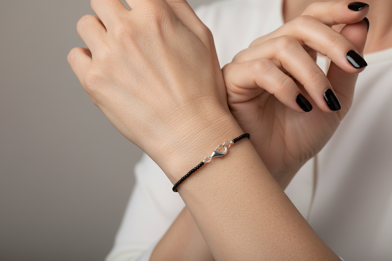 Pulsera Miyuki negra en muñeca de mujer elegante con uñas negras